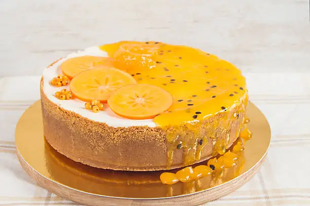 Cheesecake with passionfruit mousse decorated with slice persimmon