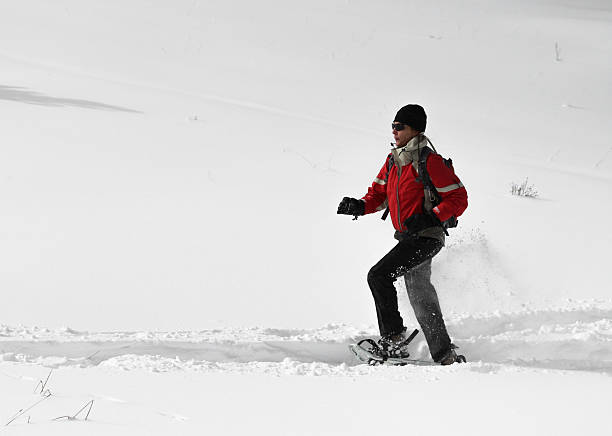 femme course en raquettes à neige - winter snowshoeing running snowshoe photos et images de collection