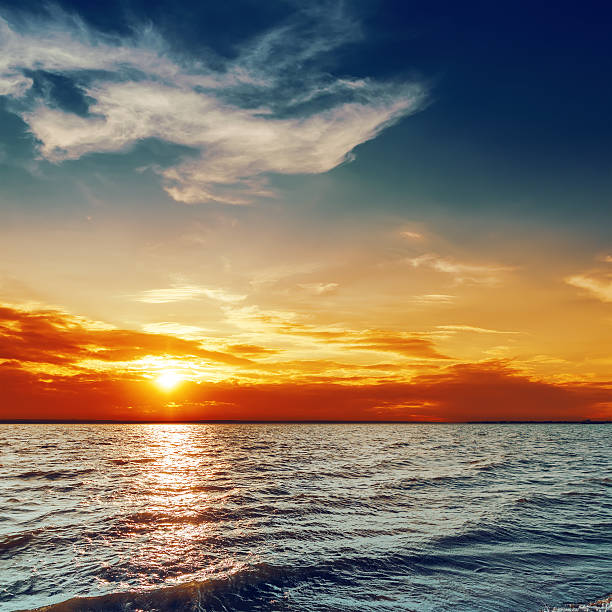 istock blue and orange sunset over darken sea 526932071