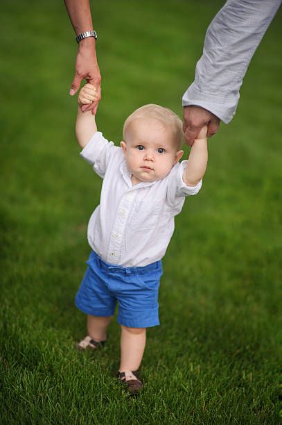 istock Happy Baby Boy Holding Parents Hands 526943209