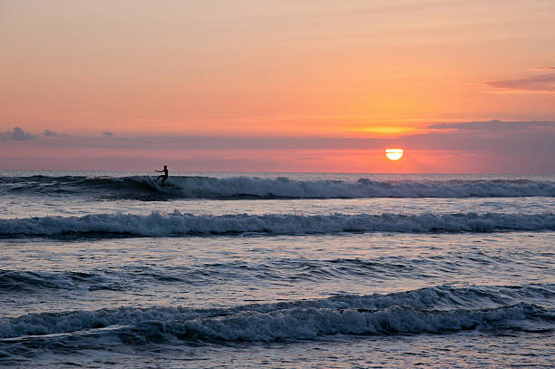 istock Blue ocean with silhouette of surfer on waves 526944511