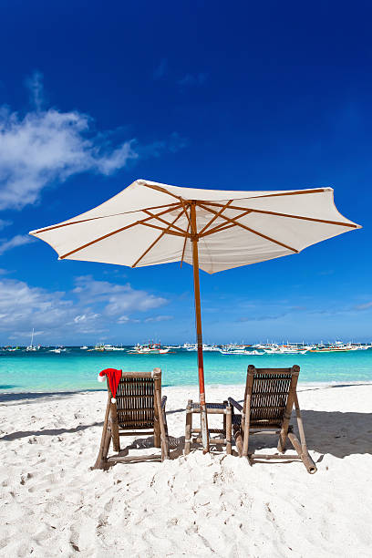 istock Sun umbrella with Santa Claus Hat on chairs 526944611