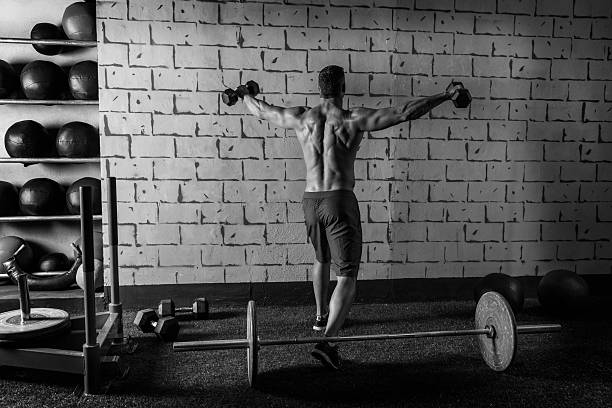 istock gym man rising hex dumbbells weightlifting rear 526948761