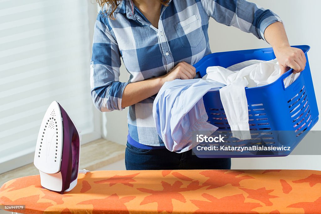 Woman with clothes before ironing View of woman with clothes before ironing Activity Stock Photo