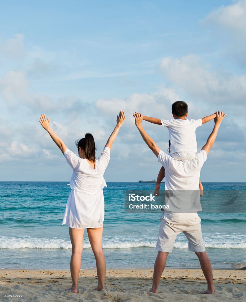 Happy family Happy family with their arms raised on the beach Adult Stock Photo