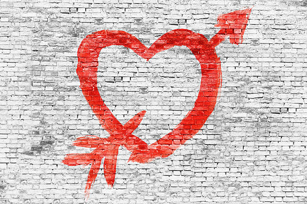 istock Heart with arrow painted over brick wall 526954519