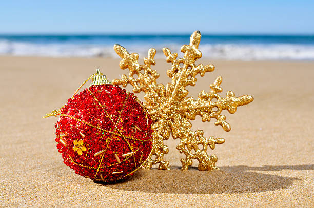 istock christmas ball and star on the beach 526955361