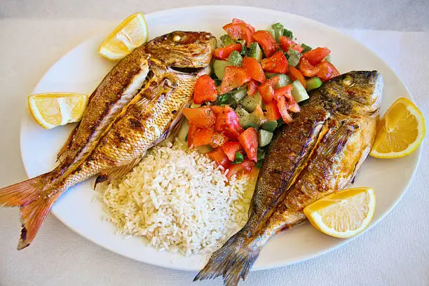 grilled gilt-head bream and red snapper served with mixed vegetables, rice and lemon