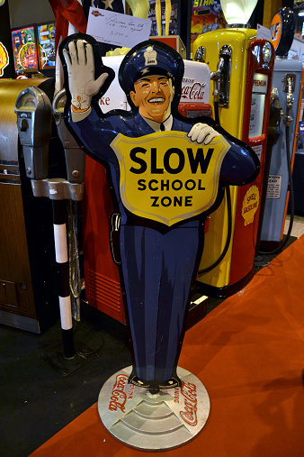 Paris, France - February 6th, 2014: The presentation of retro traffic cop figure on the Retromobile Motor Show. The antique metal sign was produced in 50s for Coca-Cola advertisement.