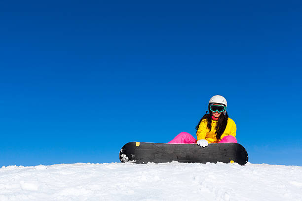 istock snowboarder woman sitting on snow mountain slope 526974601