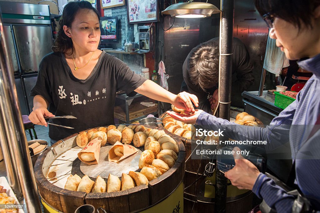 Shilin Night Market Taipei, Taiwan - November 23, 2014: Vender sells pepper pastry cake, a kind of snack popular in night market, at Shilin Night Market. Asia Stock Photo