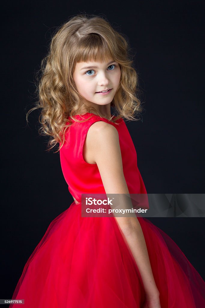 Little princess in red dress on black Portrait of young attractive girl in red dress on black  10-11 Years Stock Photo