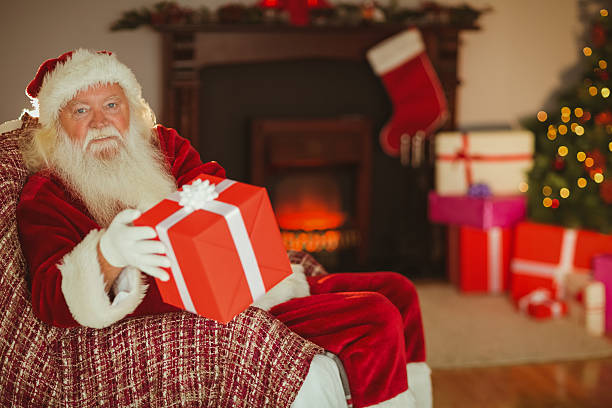 istock Cheerful santa claus offering a gift 526978403