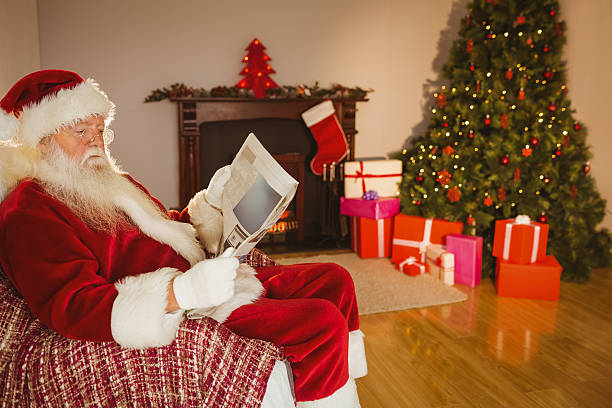 istock Santa claus reading newspaper on the couch 526978501