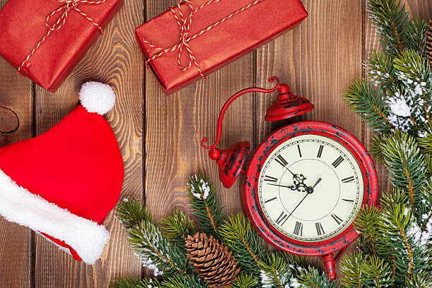 istock Christmas wooden background with clock, fir tree, gift boxes and 526978591