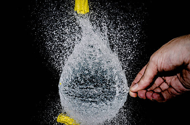 man hand holding water in black background.