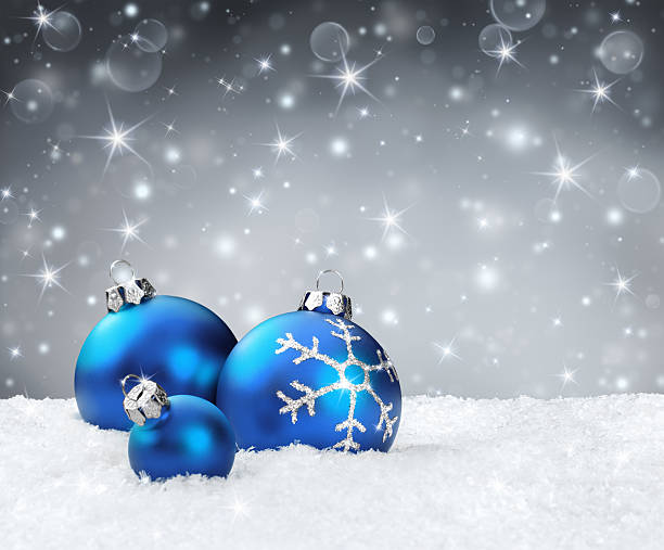 istock blue baubles on snow with silver sparkle background 526979761