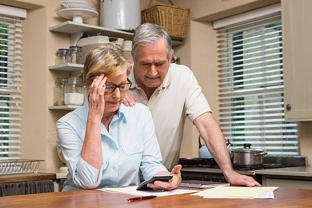 istock Senior couple working out their bills 526980177