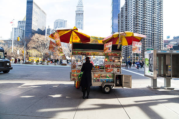 New York City, NY, USA - December 4 , 2014: A young woman buys food off Halal food cart. In the flatiron district, 23rd & 5th Ave, NYC. Madison Square Park in back. 