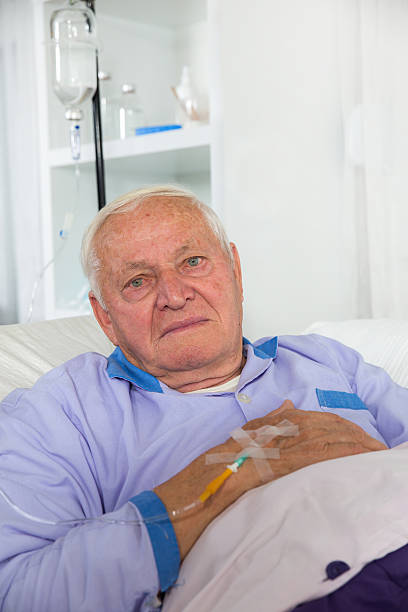 старше человек получает инфузию - infused oil iv drip nurse hospital стоковые фото и изображения