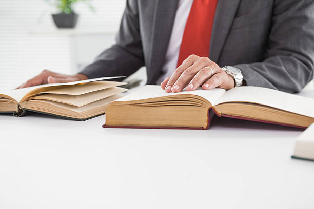 istock Businessman sitting at desk reading books 526981177