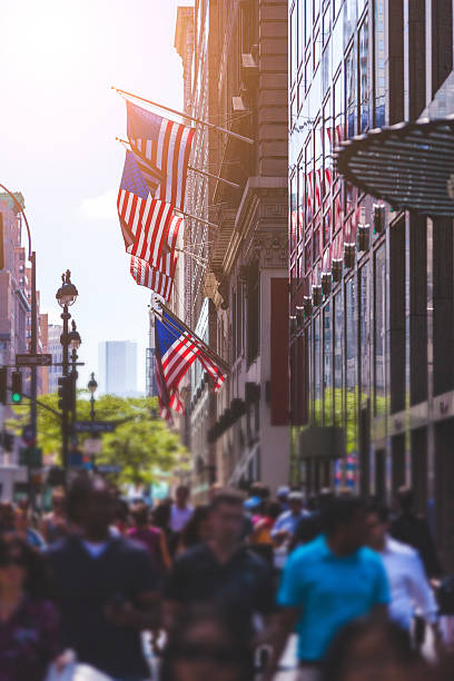 istock Crowded Sidewalk in New York and United States Flags 526981339