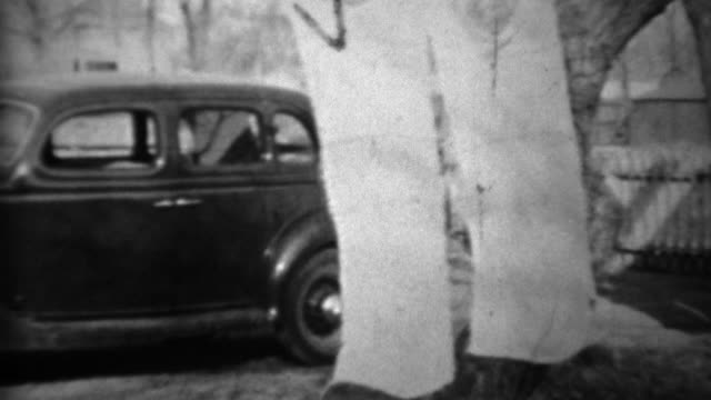 1934: New Plymouth car parked in suburban residential driveway.