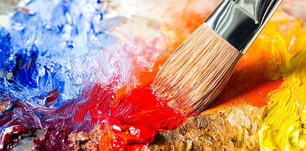 istock Paintbrush with red oil paint on a classical palette 527009097