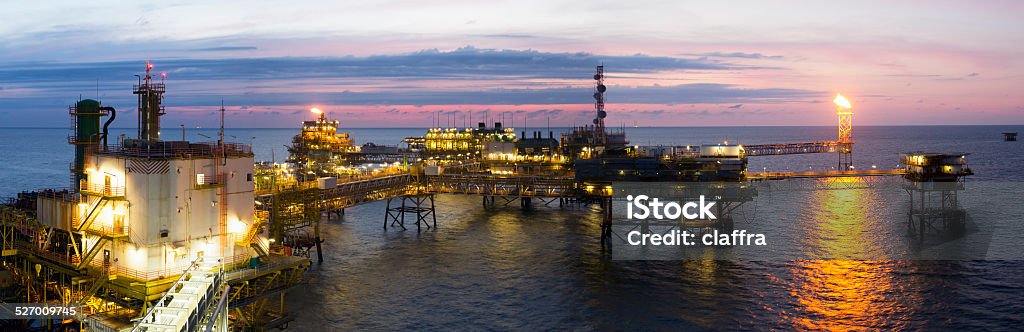 Oil platform Panoramic image of a large offshore platform in the midst of an open sea at sunset Oil Worker Stock Photo