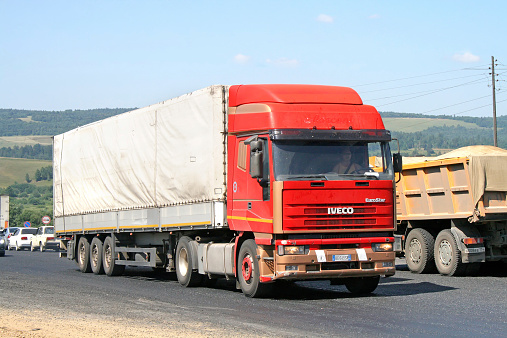 Chelyabinsk region, Russia - July 19, 2008: Red Iveco EuroStar semi-trailer truck at the interurban road.