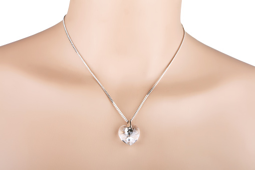 Silver necklace with heart pendant on a mannequin