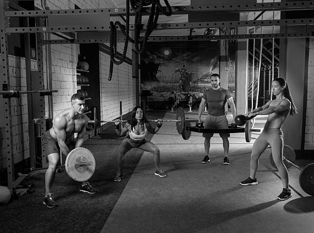 istock gym group weightlifting workout men and girls 527011665