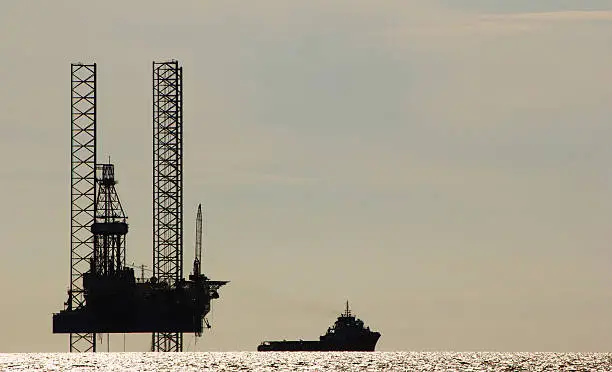 A tugboat and a drilling rig in a calm sea