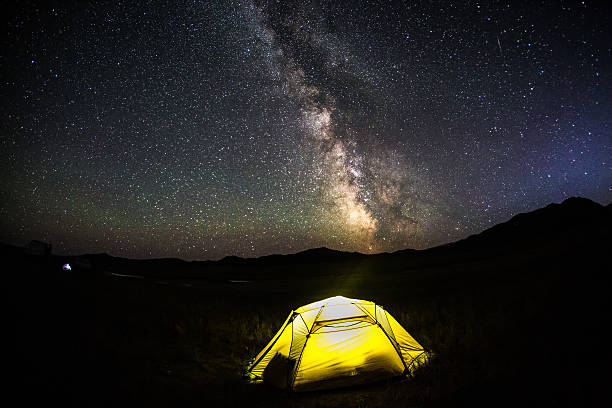istock Milky way over illuminated, yellow,  tent in Mongolia 527011947