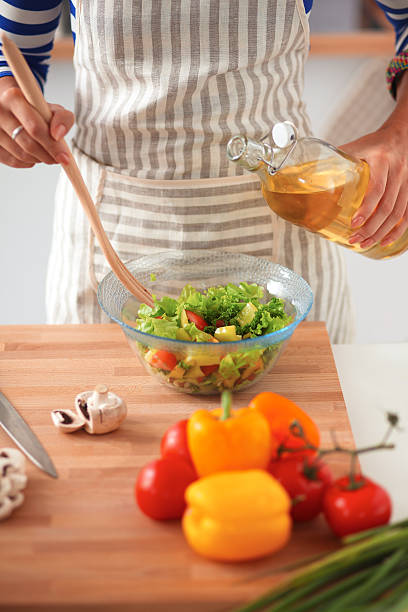 istock Smiling young woman  mixing fresh salad 527012651