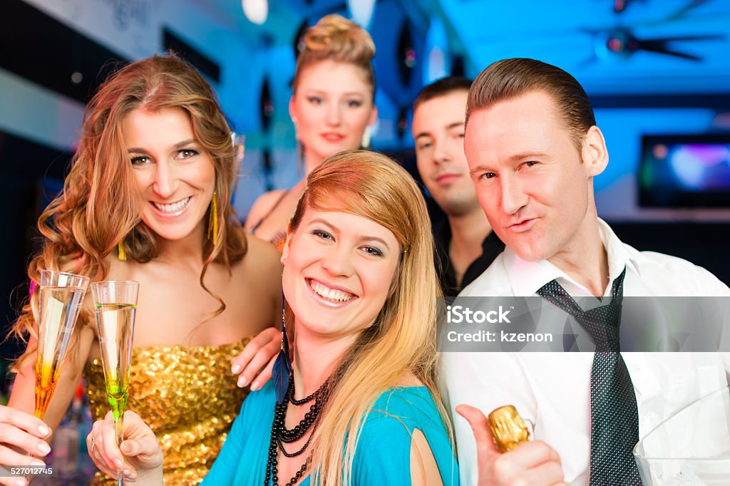 People in club or bar drinking champagne Young people in club or bar drinking champagne and having fun; one man is looking into the camera Adult Stock Photo