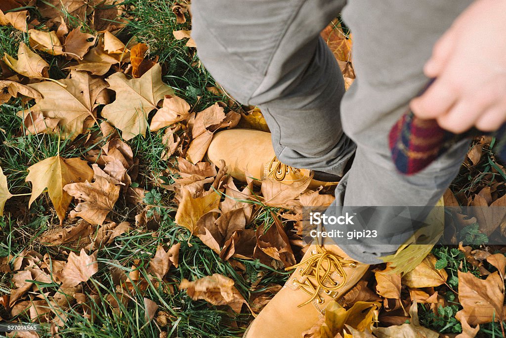 Standing among the leaves Shot of a ground covered with autumn leaves and woman standing in its midst Autumn Stock Photo