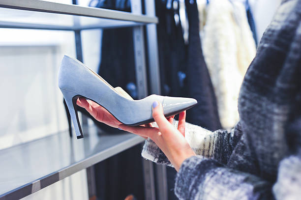 Woman shopping high heel shoes in a store stock photo