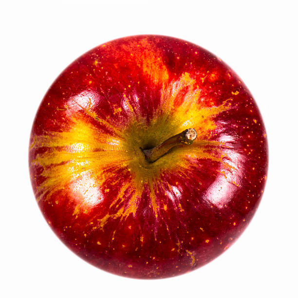 perfectly round red delicious apple photographed from above on a white background