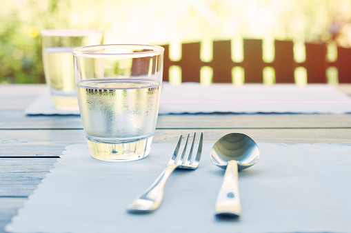 Outdoor restaurant table setting with glass, fork and spoon