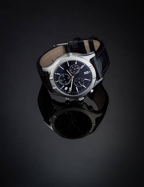 montre bracelet sur une surface réfléchissante - watch wristwatch clock hand leather photos et images de collection