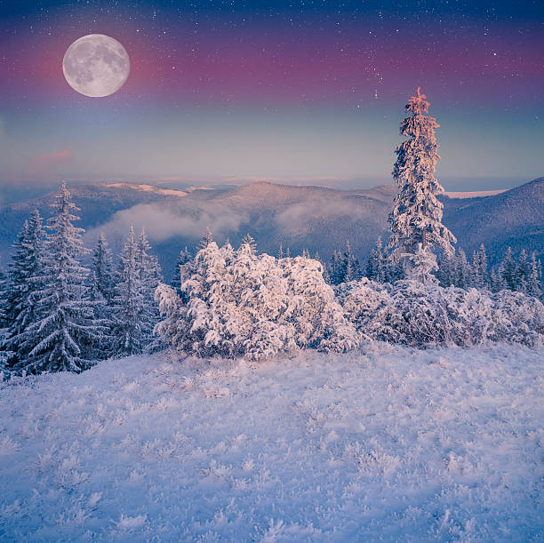 istock Rising moon over frosty winter mountains. 527029091