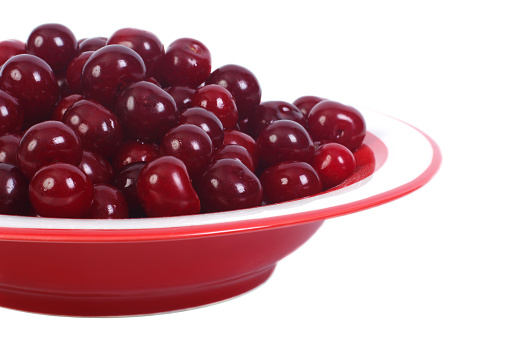 Ripe cherries in a bowl isolated on a white background. close-up