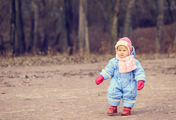 petite fille faire le premier pas dans le parc - baby first steps autumn child photos et images de collection