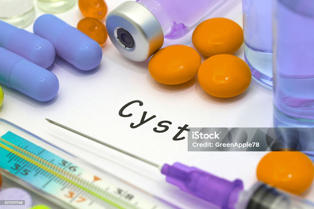 cyst cyst - diagnosis written on a white piece of paper. Syringe and vaccine with drugs. Anatomy Stock Photo