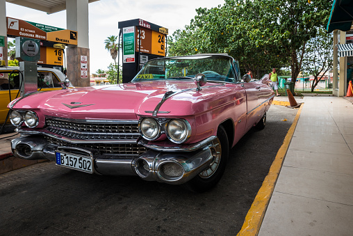 Havana, Cuba - July 03, 2015: Pink vintage cabriolet car parked on the gas station.