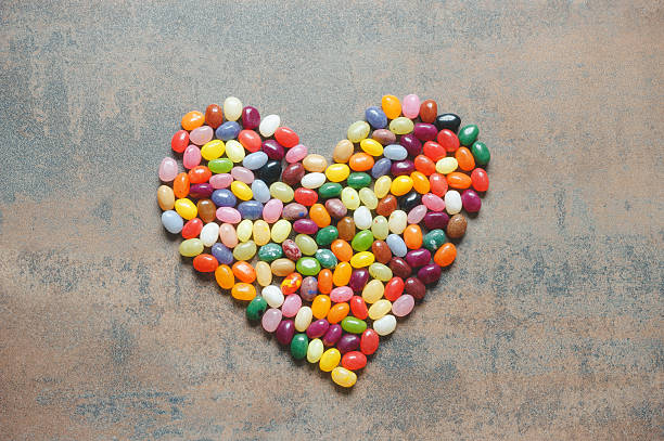 Heart symbol from jelly beans on dark background Heart symbol from jelly beans on dark background, love concept candy jellybean variation color image stock pictures, royalty-free photos & images