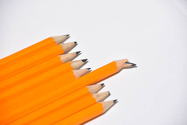 fila de una nitidez excesiva lápices amarillos, uno con rotura de la punta - breaking point fotografías e imágenes de stock