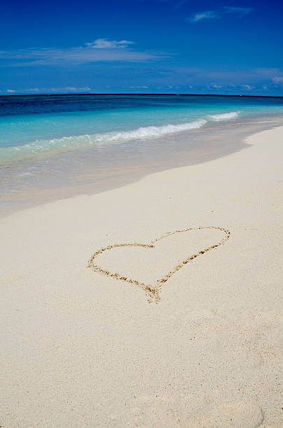 istock Heart Drawing in the White Sand Tropical Beach 527036672