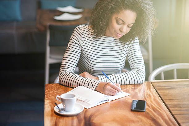 istock Beautiful african girl is making notes in cafeteria 527037632